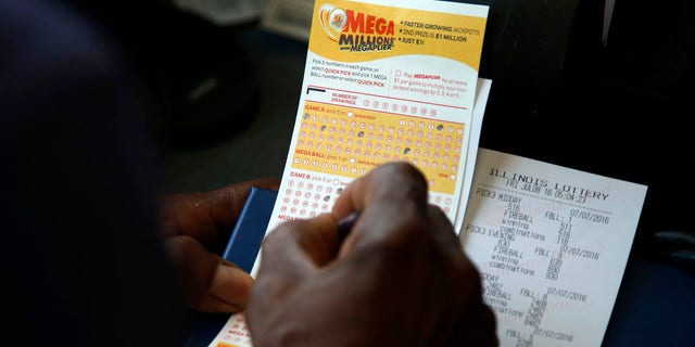 July 8, 2016: A customer picks numbers for his Mega Millions lottery ticket at a convenience store in Chicago.