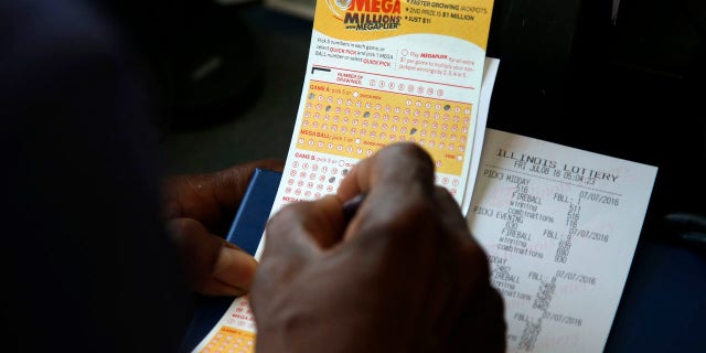 July 8, 2016: A customer picks numbers for his Mega Millions lottery ticket at a convenience store in Chicago.