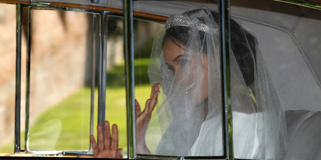 Meghan Markle waves from the car as she travels to her wedding at St. George's Chapel at Windsor Castle.
