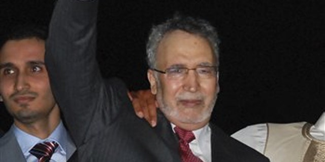In this Aug. 20, 2009, file photo, Abdelbaset al-Megrahi gestures on his arrival at an airport in Tripoli, Libya.