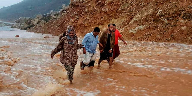 May 24, 2018: Men walk on a road flooded after heavy rain and strong winds caused damage in Hadibu as Cyclone Mekunu pounded the Yemeni island of Socotra.