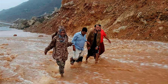 May 24, 2018: Men walk on a road flooded after heavy rain and strong winds caused damage in Hadibu as Cyclone Mekunu pounded the Yemeni island of Socotra.
