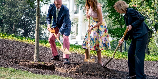 Richard Emory Gatchell, Jr., first lady Melania Trump, and Mary Jean Eisenhower participate in a presidential tree planting ceremony on the South Lawn of the White House