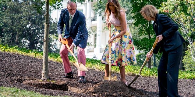 Richard Emory Gatchell, Jr., first lady Melania Trump, and Mary Jean Eisenhower participate in a presidential tree planting ceremony on the South Lawn of the White House
