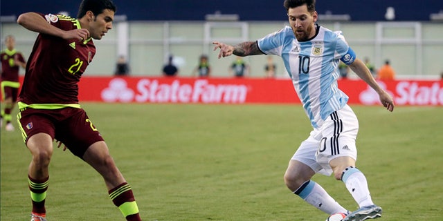 Argentina's Lionel Messi (10) dribbles the ball against Venezuela's Alexander Gonzalez (21) during the second half of a Copa America Centenario soccer quarterfinal Saturday, June 18, 2016, in Foxborough, Mass. (AP Photo/Elise Amendola)