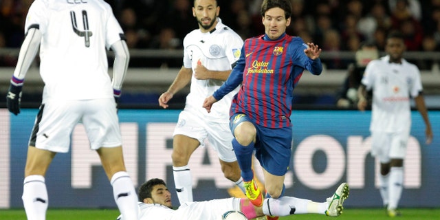 Spain's FC Barcelona midfielder Lionel Messi avoids a tackle by Qatar's Al-Sadd Sports Club defender Ibrahim Abdulmajed during their semifinal match of the Club World Cup soccer tournament in Yokohama, near Tokyo, Thursday, Dec. 15, 2011. (AP Photo/Shizuo Kambayashi)