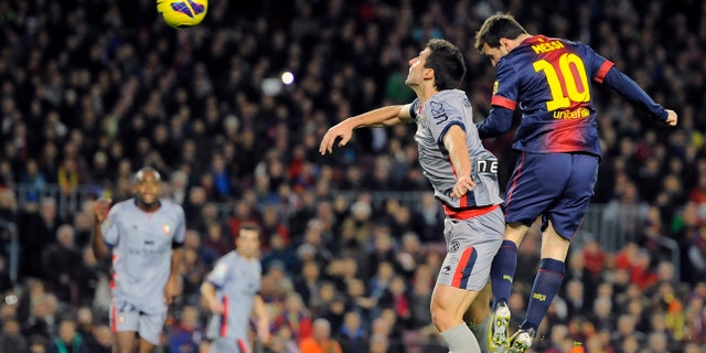 Barcelona's Lionel Messi, from Argentina, right, vies for the ball with Osasuna's Marc Bertran during their Spanish League soccer match at Camp Nou stadium in Barcelona, Spain, Sunday, Jan. 27, 2013. Barcelona won the match 5-1. (AP Photo/Alvaro Barrientos)