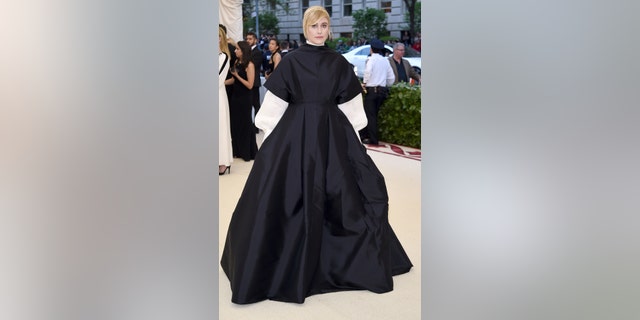 Director Greta Gerwig poses in a nun-like ball gown on the Met Gala carpet.