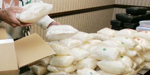 A U.S. Drug Enforcement Administration agent shows some of the 187 plus pounds of methamphetamine.