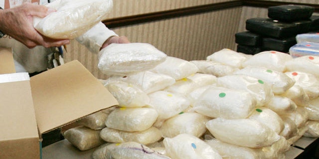 A U.S. Drug Enforcement Administration agent shows some of the 187 plus pounds of methamphetamine.