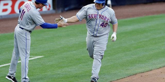 Bartolo Colon is greeted by third base coach Tim Teufel after hitting his first career home run.
