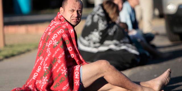 Nov. 10: Mark Rodriguez-Banks sits on the ground during an immigrant smuggling raid in Phoenix. According to a new study, 100,000 fewer Mexicans live in Arizona since its new tough immigration law.