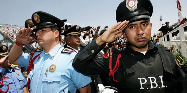 MEXICO CITY - MARCH 05: Police members salute during the Mexican National Anthem during the NASCAR Busch Series Telcel-Motorola 200 on March 5. 2006 at Autodromo Hermanos Rodriguez in Mexico City, Mexico. (Photo by Jonathan Ferrey/Getty Images)