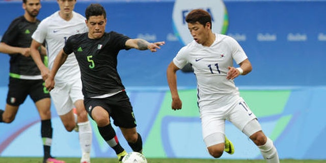 Mexico's Michael Perez, left and South Korea's Hwang Heechan vie for the ball during a group C match of the men's Olympic football tournament between South Korea and Mexico at the National Stadium in Brasilia, Brazil, Wednesday, Aug. 10, 2016. South Korea won the game 1-0. (AP Photo/Eraldo Peres)