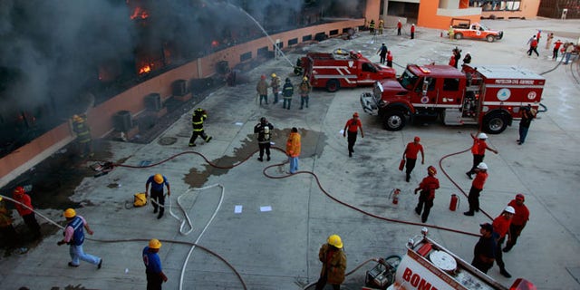 Oct. 13, 2014: Firefighters try to extinguish the flames after the state capital building was set on fire by protesting college students in Chilpancingo, Mexico