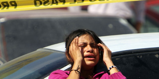 JUAREZ, MEXICO - MARCH 22: Family members grieve in front of a car in which two men lay dead on March 22, 2010 in Juarez, Mexico. Both men, who were 18 and 34 years of age, were shot by a group of teenagers. The border city of Juarez, Mexico has been racked by violent drug related crime recently and has quickly become one of the most dangerous cities in the world to live. As drug cartels have been fighting over ever lucrative drug corridors along the United States border, the murder rate in Juarez has risen to 173 slayings for every 100,000 residents. President Felipe Calderon?s strategy of sending 7000 troops to Juarez has not mitigated the situation. With a population of 1.3 million, 2,600 people died in drug-related violence last year and 500 so far this year, including two Americans recently who worked for the U.S. Consulate and were killed as they returned from a children?s party. (Photo by Spencer Platt/Getty Images)