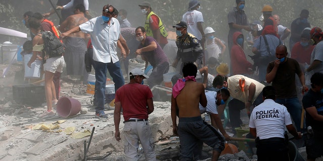 Volunteers search a building that collapsed after an earthquake, in the Roma neighborhood of Mexico City, Sept. 19, 2017