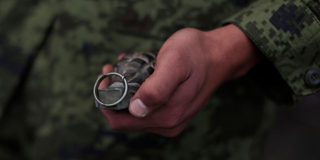 In this file photo, a soldier holds a grenade in Mexico City, Mexico.