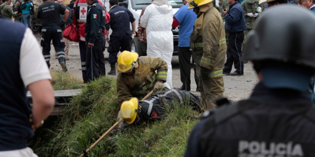 March 15, 2013: Emergency workers search for human remains in a ditch after a truck loaded with fireworks exploded during a religious procession in the town of Nativitas, Mexico.