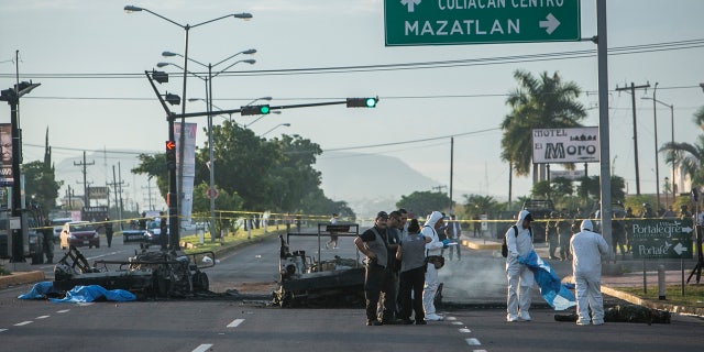 Sept. 30, 2016: Police investigators examine the site where a military convoy was ambushed using grenades and high-powered guns, killing five soldiers in the city of Culiacan, Mexico.