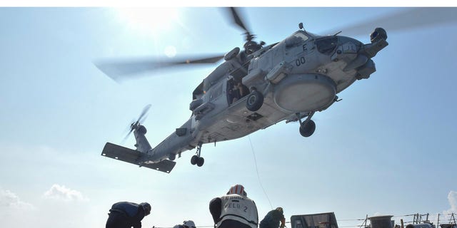 U.S. Navy Sailors participate in a medical training exercise on the deck of the Arleigh Burke-class guided missile destroyer USS Lassen (DDG 82) with an MH-60R Seahawk helicopter, in the South China Sea, October 28, 2015, provided by the U.S. Navy.
