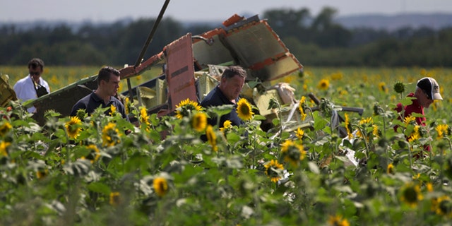 July 25, 2014: Dutch and Australian investigators examine pieces of the crashed Malaysia Airlines Flight 17 in the village of Rassipne, Donetsk region, eastern Ukraine.