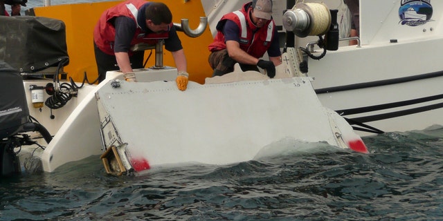 A Boeing 777 flaperon cut down to match the one from flight MH370 found on Reunion island off the coast of Africa in 2015, is lowered into water to discover its drift characteristics by Commonwealth Scientific and Industrial Research Organisation researchers in Tasmania, Australia, in this handout image taken March 23, 2017.