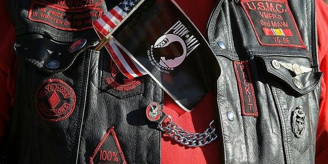 A veteran wears a US and POW-MIA flag together on his vest