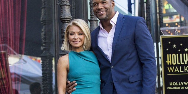 Television personality Kelly Ripa poses on her star with former professional American football player Michael Strahan after it was unveiled on the Hollywood Walk of Fame in Los Angeles, California October 12, 2015.  REUTERS/Mario Anzuoni - RTS4654