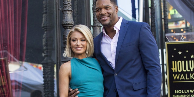 Television personality Kelly Ripa poses on her star with former professional American football player Michael Strahan after it was unveiled on the Hollywood Walk of Fame in Los Angeles, California October 12, 2015. REUTERS/Mario Anzuoni - RTS4654