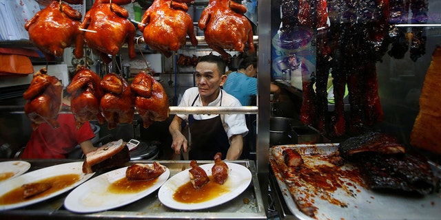 Hawker Chan Hong Meng, who won a Michelin star, sells soya sauce chicken at his Hong Kong Soya Sauce Chicken Rice and Noodle stall at Chinatown food center in Singapore. His stall's signature dish cost just $5.20 when he was awarded the honor in 2016.