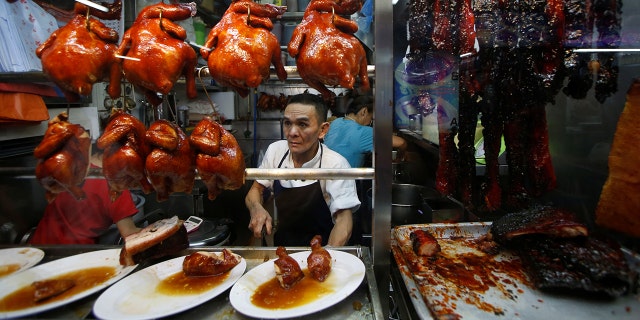 Hawker Chan Hong Meng, who won a Michelin star, sells soya sauce chicken at his Hong Kong Soya Sauce Chicken Rice and Noodle stall at Chinatown food center in Singapore. His stall's signature dish cost just $5.20 when he was awarded the honor in 2016.