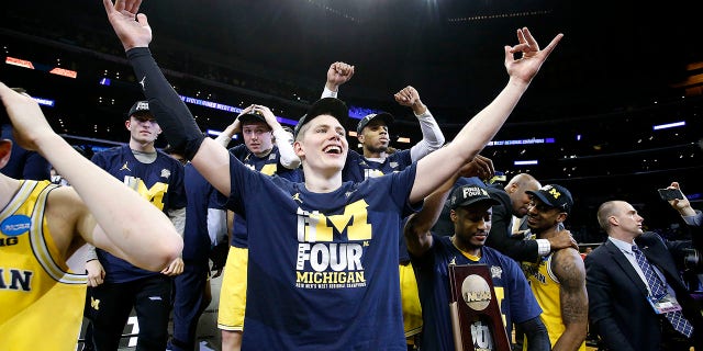 Michigan forward Moritz Wagner, foreground, and teammates celebrate after defeating Florida State 58-54 in an NCAA men's college basketball tournament regional final, in Los Angeles, March 24, 2018.