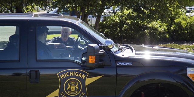 Michigan State Police talk outside Bishop International Airport, Wednesday morning, June 21, 2017, in Flint, Mich.