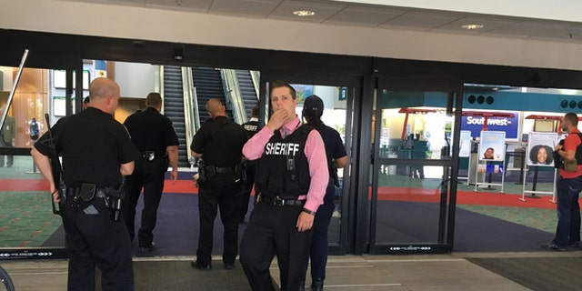 Police officers gather at Bishop International Airport after the attack on June 21, 2017.