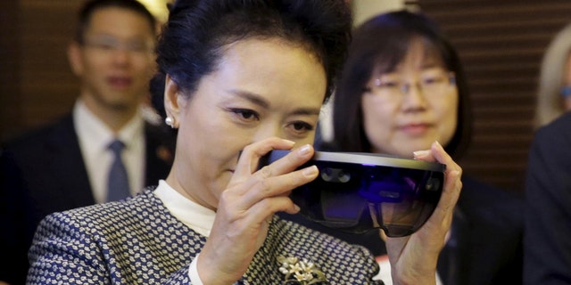 File photo - Peng Liyuan, wife of Chinese President Xi Jinping, examines Microsoft's HoloLens device during a tour of Microsoft's main campus in Redmond, Washington Sept. 23, 2015. (REUTERS/Ted S. Warren/Pool)