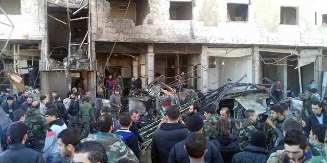 Syrians gather at the spot where bombs exploded in Damascus.