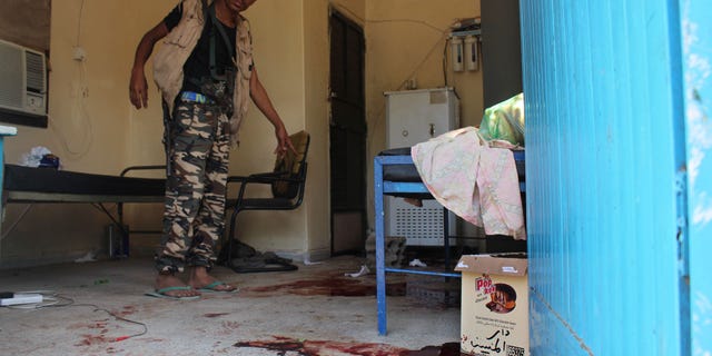 A Yemeni man inspects an elderly care home that was attacked Friday by unidentified gunmen.