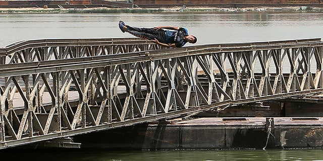 A man dives into the Shat al-Arab river in Basra Iraq. An unprecedented heat wave prompted Iraqi authorities to declare a mandatory four-day holiday beginning Thursday. The government has urged residents to stay out of the sun and drink plenty of water. (AP Photo/ Nabil al-Jurani)