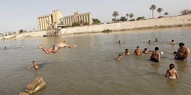 Residents dive into the Tigris river to take a swim and cool off in northern Baghdad's Adhamiya district. A searing heat wave through Iraq prompted the government to declare a four-day "Heat Holiday." (REUTERS/Ahmed Saad)
