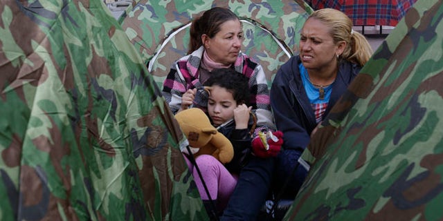Dozens of Cubans are camped out in front of Mexico's embassy appealing for help in reaching the United States, in Quito, Ecuador, Tuesday, June 21, 2016. They apparently seek something like an international operation earlier this year that lifted thousands of Cubans from Costa Rica to Mexico, so that they could reach the U.S. Unlike any other nationality, Cubans are essentially granted residence if they reach U.S. territory. (AP Photo/Dolores Ochoa)