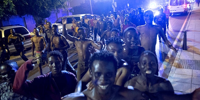 African migrants react after crossing the border from Morocco to Spain's North African enclave of Ceuta.
