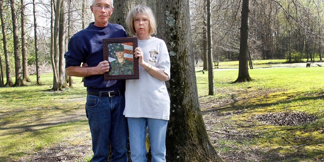April 19, 2010: Matt and Cheryl Ecker hold a photo of their son, Army veteran Michael Ecker, in Champion, Ohio. On a warm summer afternoon in Champion, Michael Ecker, 25, an Iraq war veteran, called out to his father from a leafy spot in their backyard. Then, as the two stood just steps apart, Michael saluted, raised a gun to his head and pulled the trigger.