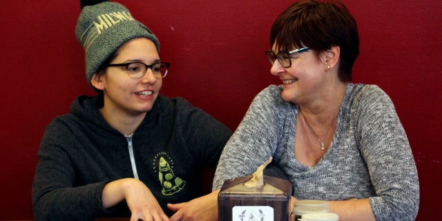In this Jan. 9, 2017, photo, Andrea Ledesma, left, talks with her mother, Cheryl Romanowski, at Classic Slice pizza restaurant, where Ledesma works, in Milwaukee.