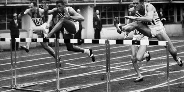 July 26, 1952: This file photo shows Milt Campbell, center, of Plainfield, N.J. getting set to clear the final hurdle to make him the winner in the fifth heat of the 110-meter hurdles event in the Olympic decathlon at Helsinki, Finland.