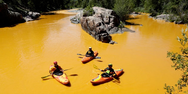 Aug. 6, 2015: People kayak in the Animas River near Durango, Colo., in water colored from a mine waste spill.