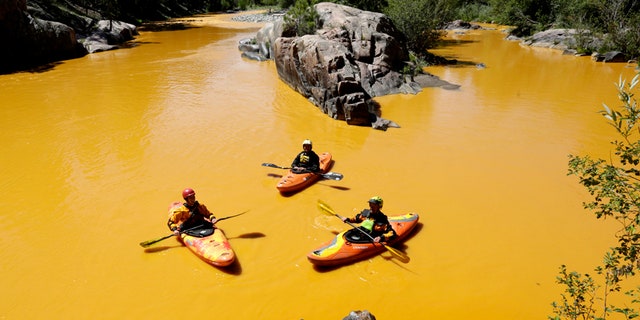 Aug. 6, 2015: People kayak in the Animas River near Durango, Colo., in water colored from a mine waste spill.