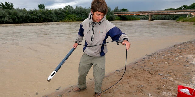 Aug. 11, 2015: Ben Brown, with the Utah Department of Environmental Quality, takes a pH level reading from a probe in the San Juan River Montezuma Creek, Utah.