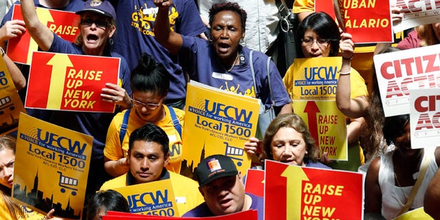 FILE: June 17, 2014: Protesters rally for an increase in the minimum wage on the Great Western Staircase at the capitol, in Albany, N.Y.