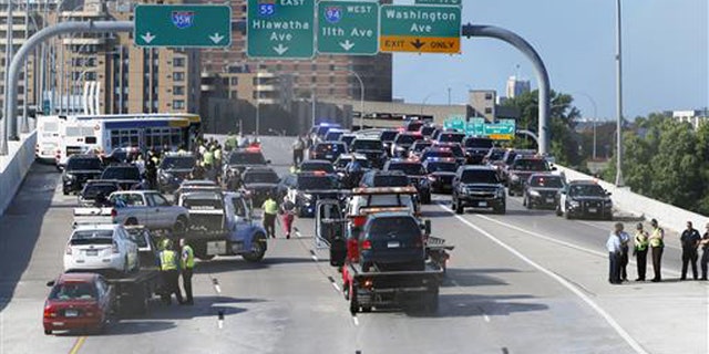State troopers and police clear the Interstate 35W freeway where protesters blocked the highway leading into Minneapolis over the Mississippi River bridge during rush hour Wednesday, July 13, 2016.